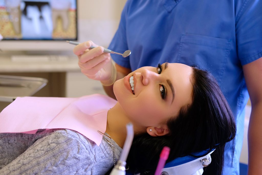 Manos de un odontologo trabajando con instrumental dental