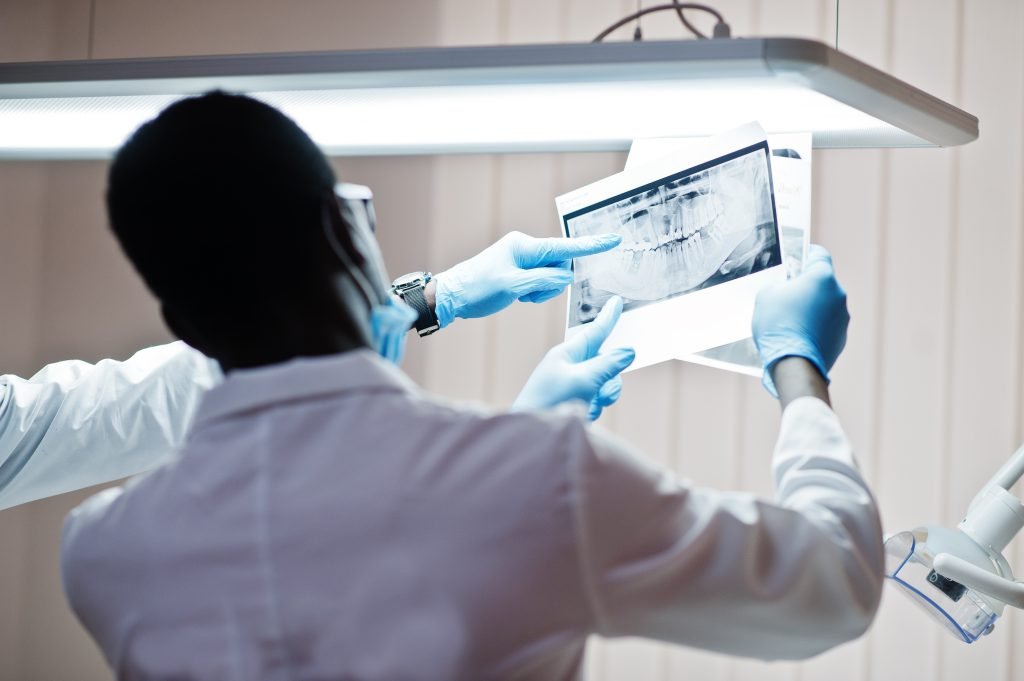 Profesional senalando una radiografia dental